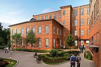 Exterior view of the Cable Mills facility, while a number of residents enter and exit the building. 