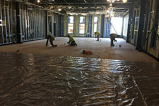 College of the Holy Cross - Installation of REGUPOL acoustics to the Flooring Four construction employees install REGUPOL acoustic products to the flooring in the Joanne Chouinard-Luth Recreation and Wellness Center at the College of the Holy Cross.