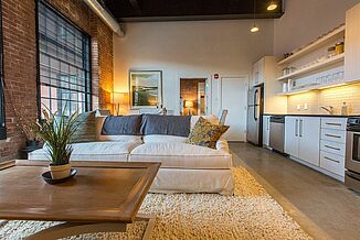 View of living room and kitchen in the Cable Mills residential facility. The facility utilized REGUPOL acoustics to ensure premium noise features for residents.